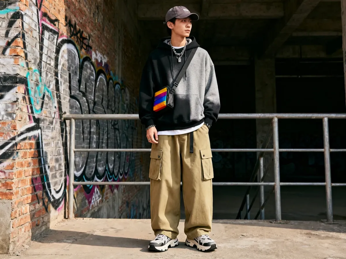 Kompletna stylizacja streetwear z bluzą, szerokimi spodniami, sneakersami i dodatkami